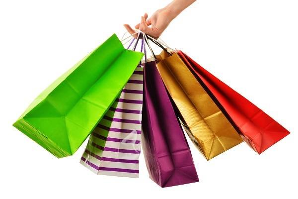Female hand holding paper shopping bags isolated on white background