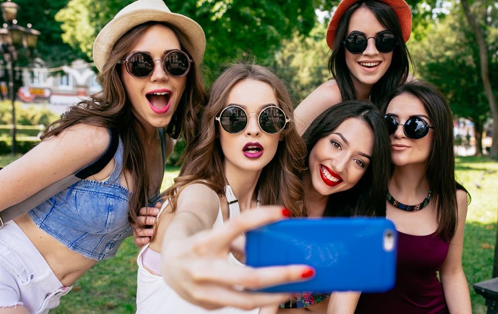 five beautiful young girls make selfie in the park