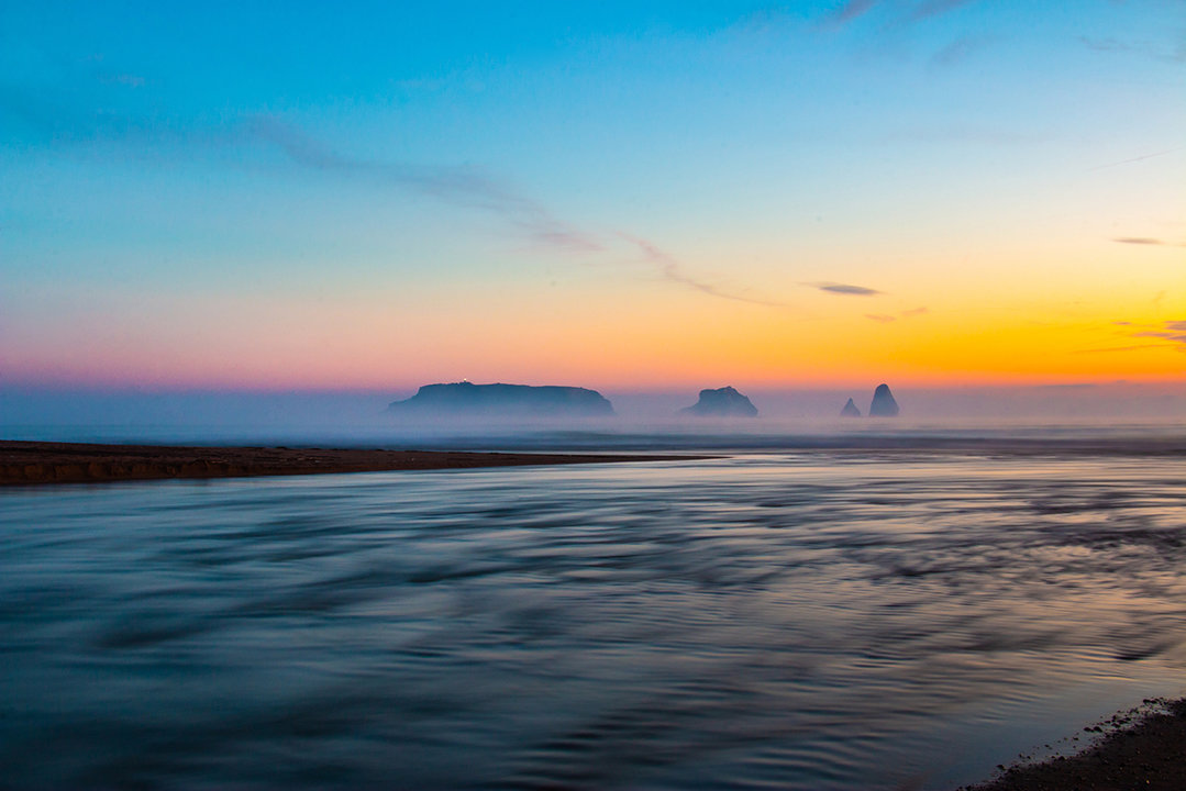 Landscape of a river flowing at dawn in morning with a calm atmosphere with mist. Mouth of river Ter in the Mediterranean Sea with the Medes Islands. Tourism Torroella de Montgri, Ampurdán, Catalonia.