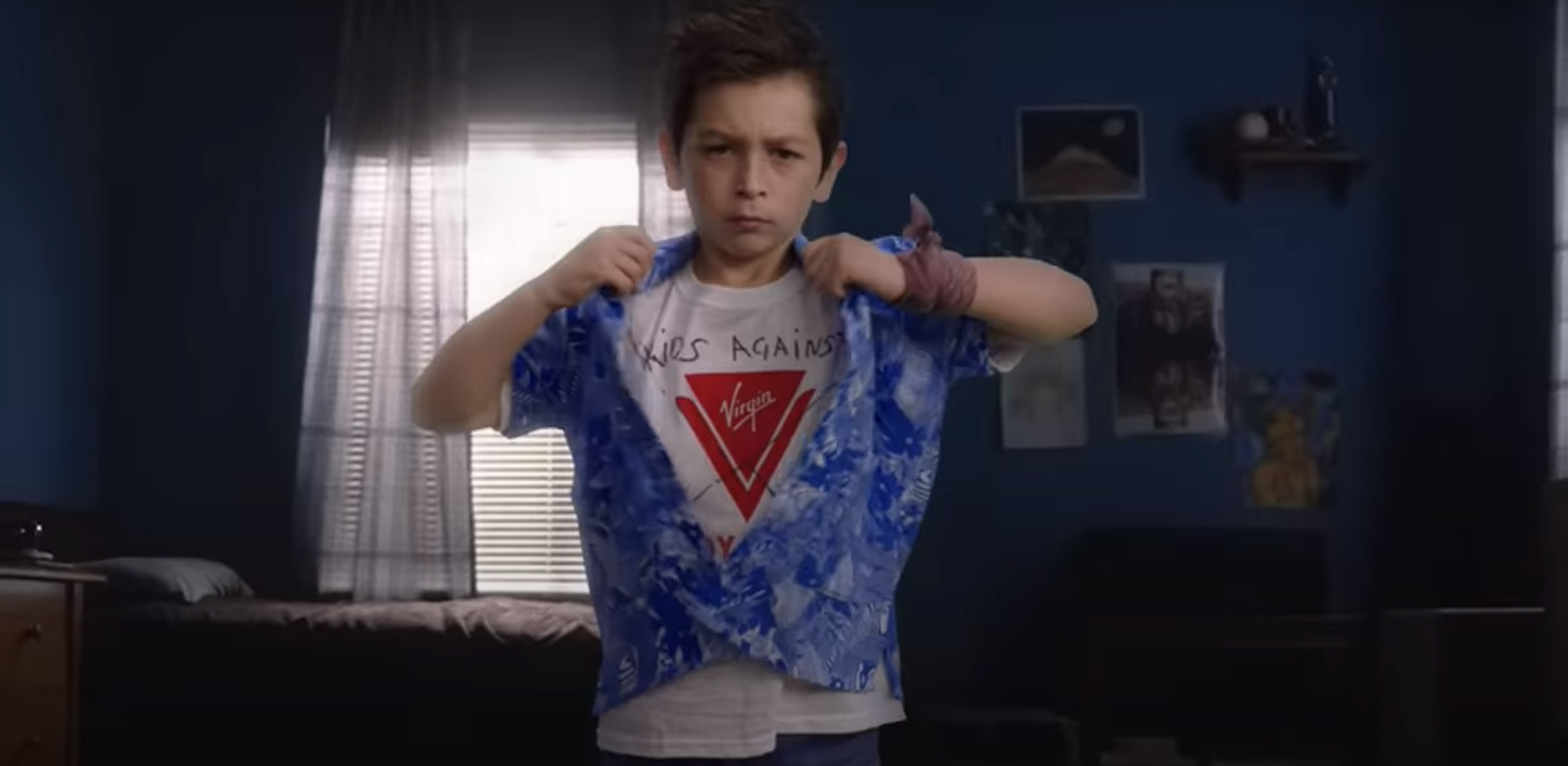 Un niño muestra una camiseta en señal de disconformidad con Virgin